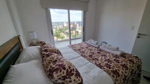 a bedroom with a bed with a large window at Comfort Patagonia Inn in Neuquén