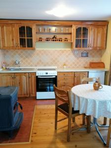 uma cozinha com uma mesa e um fogão em Vila Milija em Bajina Bašta