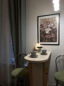 uma pequena mesa com cadeiras e um quadro na parede em Sunflower B&B em Kiev