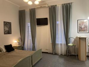 a bedroom with a bed and a flat screen tv at Sunflower B&B in Kyiv