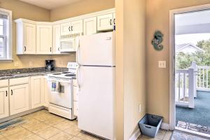 a kitchen with white cabinets and a white refrigerator at Bright and Airy Resort Condo Golf, Shop and Swim in North Myrtle Beach