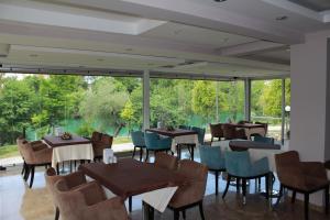 a restaurant with tables and chairs and a large window at River Hotel in Manavgat