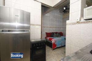 a kitchen with a refrigerator and a bed in a room at Apartamento Botafogo in Rio de Janeiro