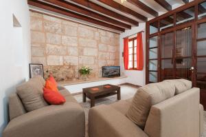 una sala de estar con 2 sofás y una pared de ladrillo en YupiHome Holiday Home Ca Na Blan ca, en Alcudia