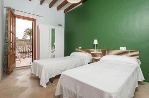 due letti in una stanza con una parete verde di Holiday Home Ca Na Blan ca a Alcudia Altre 15 foto