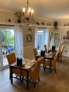卡莱尔Abbey Court Guest House的一间有桌椅和枝形吊灯的餐厅
