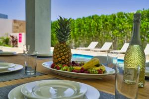 a table with a plate of fruit and a bottle of wine at GRAND Modern villa 6-Bedroom Brand New Heated Jacuzzi in Palm-Eagle Beach