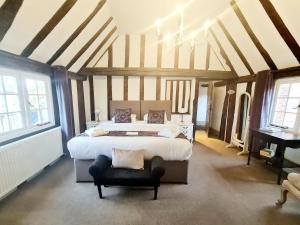 a large bedroom with a large bed and a piano at The Harvard Inn in Stock