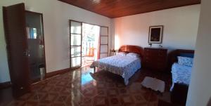 Un dormitorio con una cama y una cómoda y una ventana. en Pousada Pedacinho do Ceu chale 2, en Cunha