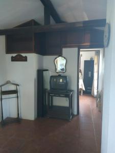 Zimmer mit einem TV und einem Tisch mit einem Spiegel in der Unterkunft Paraíso Serrano in Villa Serrana