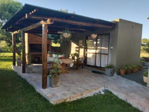 eine Terrasse im Hinterhof mit einer hölzernen Pergola in der Unterkunft Paraíso Serrano in Villa Serrana