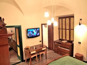 a living room with a table and a tv on the wall at LOVINGENOA DUCALE in Genoa
