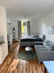 a living room with a bed and a couch at Zentrale Ferienwohnung mit Balkon in Aachen in Aachen