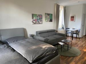 - un salon avec un lit et un canapé dans l'établissement Zentrale Ferienwohnung mit Balkon in Aachen, à Aix-la-Chapelle
