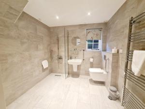 a bathroom with a toilet sink and a shower at The Harvard Inn in Stock