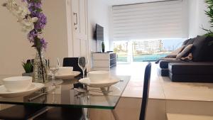 una sala da pranzo con tavolo in vetro e bicchieri da vino di Spinola Seafront Apartment a San Giuliano