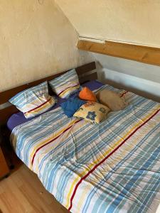 een bed met kussens in een kamer bij CHAMBRE FamilIale in Nandy