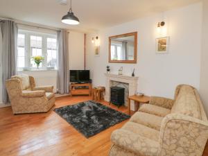 a living room with two chairs and a fireplace at Weavers Cottage in Dursley