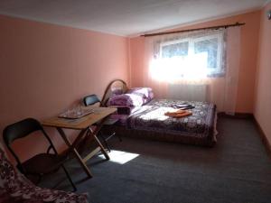 Habitación con cama, mesa y ventana en Cheres Hotel, en Yablunytsya