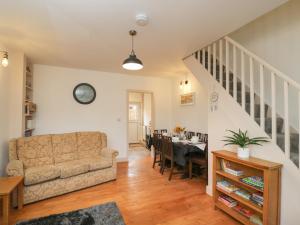ein Wohnzimmer mit einem Sofa und einem Tisch in der Unterkunft Weavers Cottage in Dursley