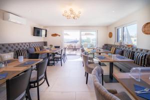 a restaurant with tables and chairs and a chandelier at bodenseezeit Apartmenthotel Garni in Lindau