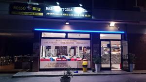 una tienda frente a un restaurante por la noche en Hotel Marco Polo SELF CHECK-IN en Bolonia