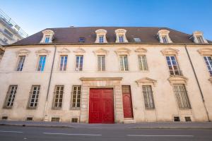 - un bâtiment avec deux portes rouges dans une rue dans l'établissement Le Mucie*****LOFT au centre ville de Dijon, à Dijon