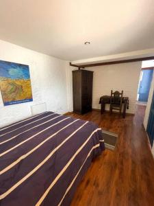 a bedroom with a bed and a painting on the wall at Suite in beautiful Historical Guapulo, Quito in Quito