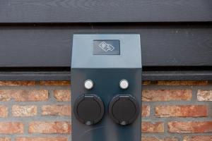 a computer with headphones attached to a brick wall at B&B In ons straatje in Rosmalen