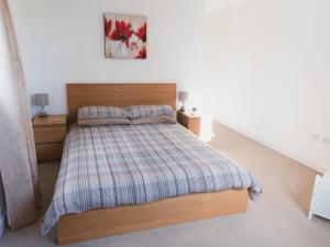 a bedroom with a bed with a plaid blanket at Pass the Keys Lovely 2-Bed Flat Glasgow Harbour FREE parking in Glasgow