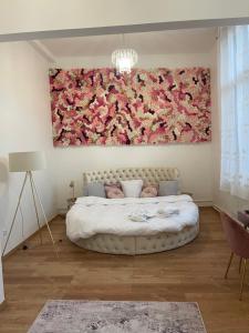 a bedroom with a large flower painting on the wall at Golden Suite - JACUZZI SAUNA in Rouen