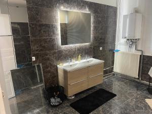 La salle de bains est pourvue d'un lavabo et d'un miroir. dans l'établissement Golden Suite - JACUZZI SAUNA, à Rouen