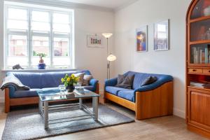 ein Wohnzimmer mit 2 blauen Sofas und einem Tisch in der Unterkunft Stadthaus Jürgensby in Flensburg