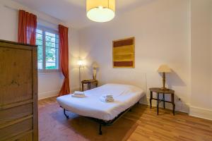 a bedroom with a bed and two tables and a window at Le Chaussier, en plein centre ville de Dijon in Dijon