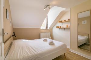 une petite chambre avec un lit et un miroir dans l'établissement Le Godrans, en plein centre ville de Dijon, à Dijon