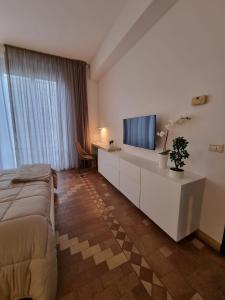 a bedroom with a bed and a flat screen tv at GRAFEA Apartment Catania in Catania