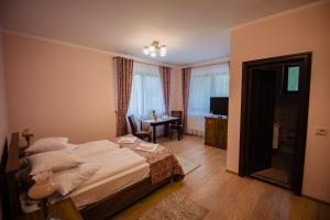 a bedroom with a bed and a table and a desk at Casa Măiereană in Anieş