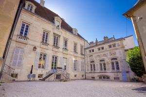 un grand bâtiment avec un escalier en face de celui-ci dans l'établissement L'historique au cœur de ville, à Dijon