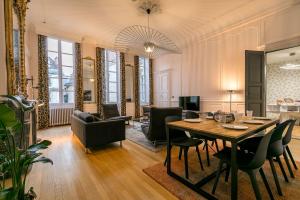 a dining room and living room with a table and chairs at L'historique au cœur de ville in Dijon