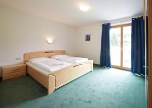 a bedroom with two beds and a large window at Appartement Mitteregg in Saalbach Hinterglemm