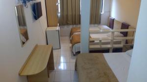a small room with two beds and a table at Casa Hospedagem Diamantina in Diamantina +3 photos