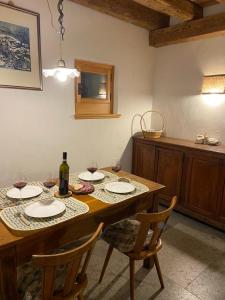 - une table en bois avec des verres à vin et une bouteille de vin dans l'établissement Al Salt, à Belluno