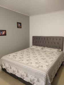 a bedroom with a bed in a white room at Hospedagem dona Tania in Canela