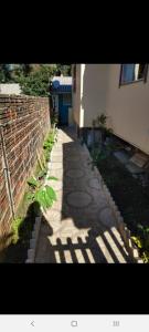 a sidewalk next to a building with a brick wall at Hospedagem dona Tania in Canela