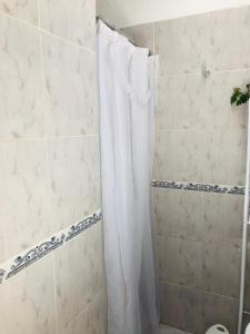 Una ducha con una cortina de ducha blanca en un baño. en Espacio Edison 3, en Santa Rosa