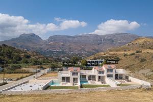 a house on a hill with mountains in the background at Mythos villas in Damnoni