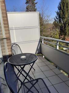 um pátio com uma mesa e cadeiras numa varanda em Apartment am Park em Dusseldorf