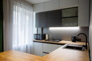 尼古拉耶夫的住宿－NEW!!! Новая квартира класса Люкс в центре города，厨房配有黑色橱柜和木制台面