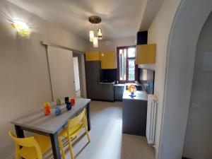 eine Küche mit einem Tisch und gelben Stühlen in einem Zimmer in der Unterkunft Residenza Donini in Venice Suite 2 in Venedig