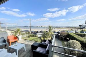 uma varanda com cadeiras e vista para a praia em LUXURY T3 neuf de standing Front de mer vue 180 em Larmor-Plage